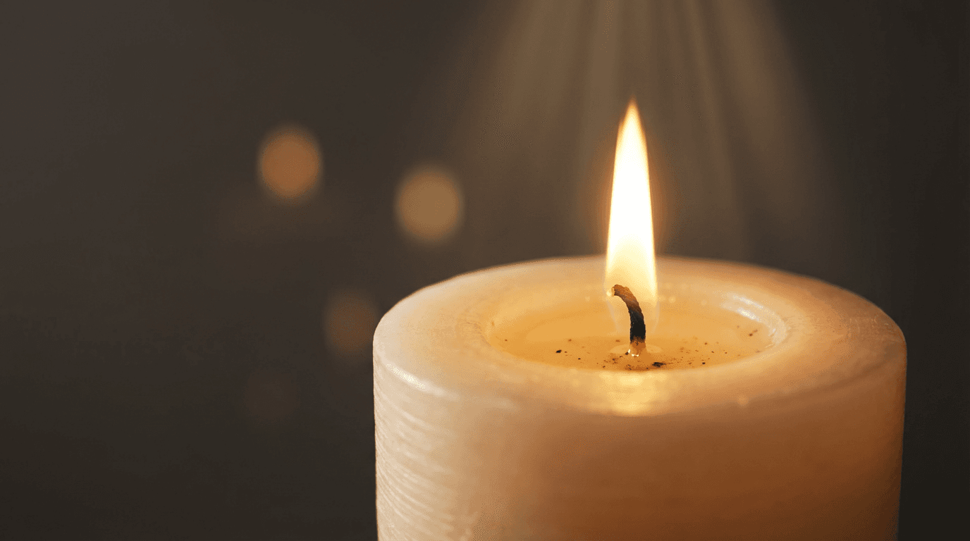 A peaceful chapel corner with a wooden bench and a lit candle by a window